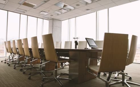 a conference room with a long table and chairs and a computer on it