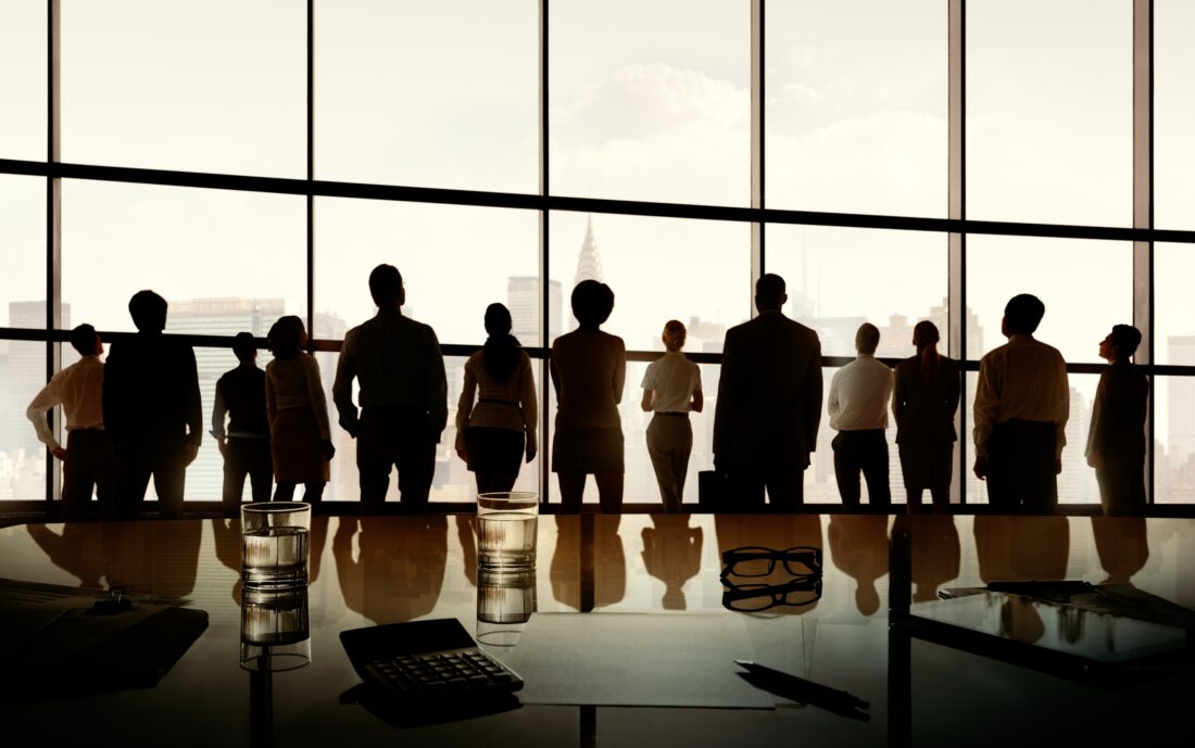 a group of people standing in front of a large window