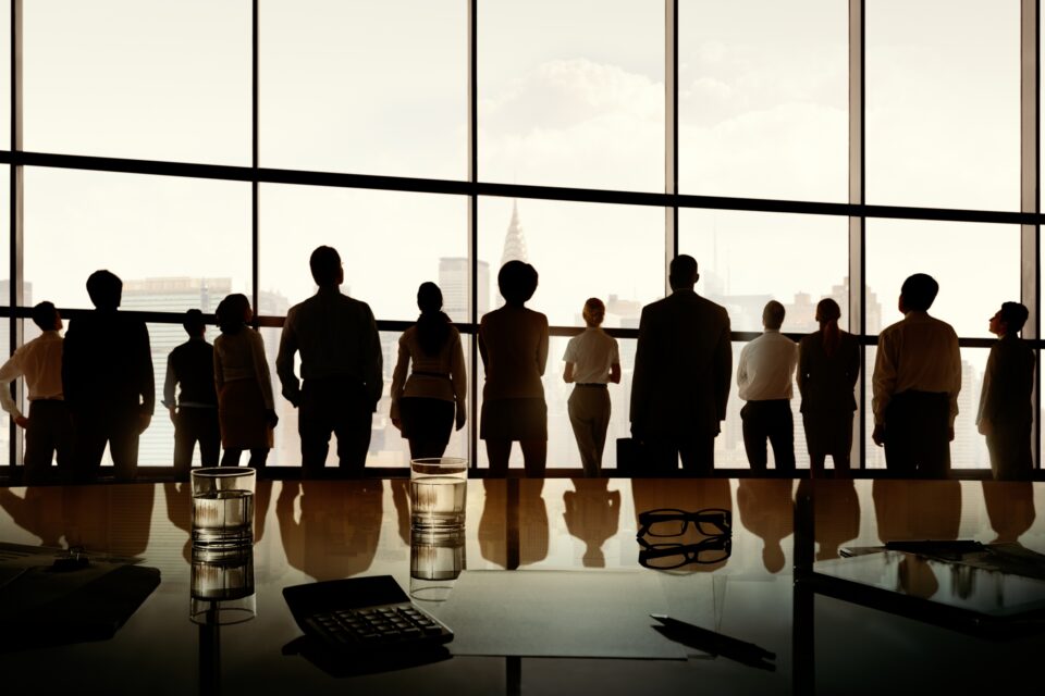a group of people standing in front of a large window
