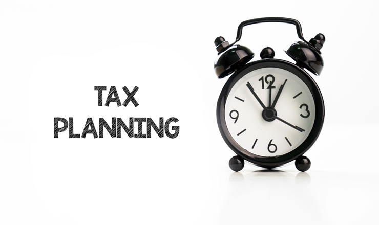 a black and white alarm clock with the words Tax Planning to the right of it