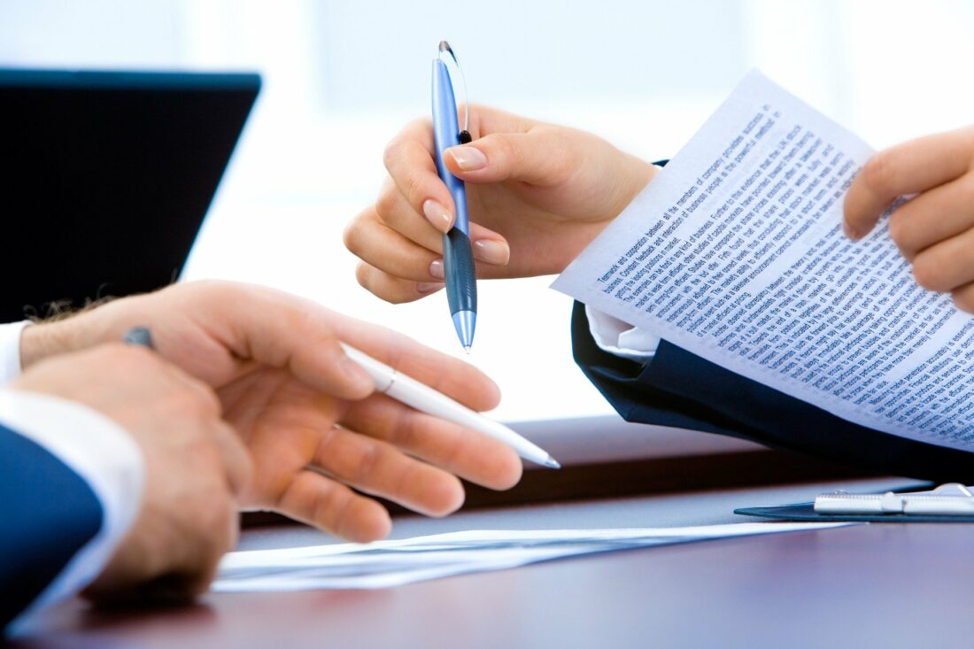 a person holding a pen over a piece of paper that says "termination agreement"