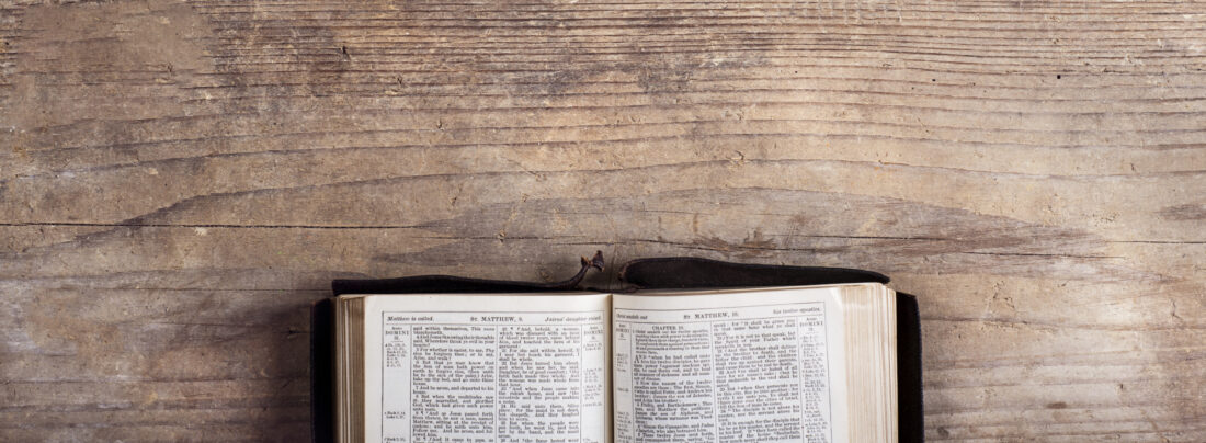 a bible on a wood table open to the book of psalms