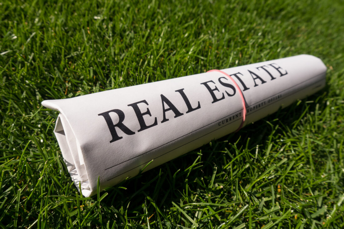 a rolled up newspaper with the word real estate on it