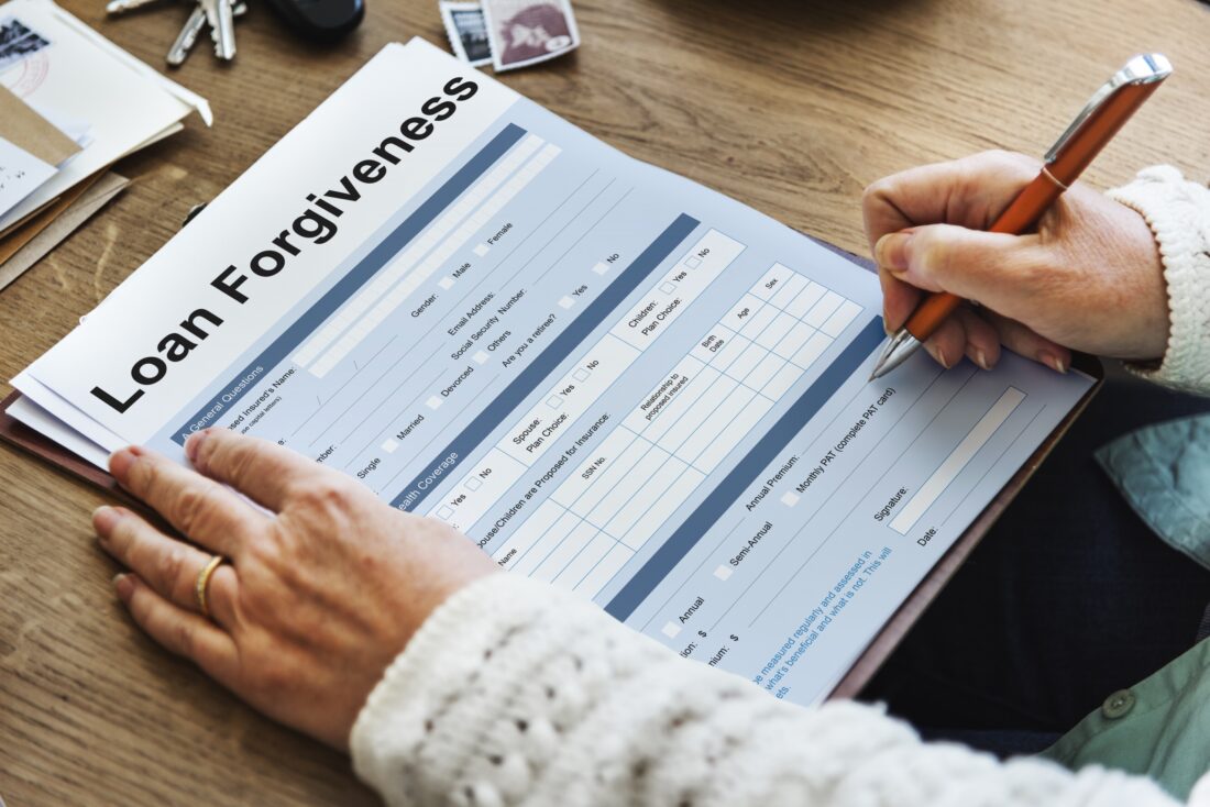 close-up of a person filling out a loan forgiveness form