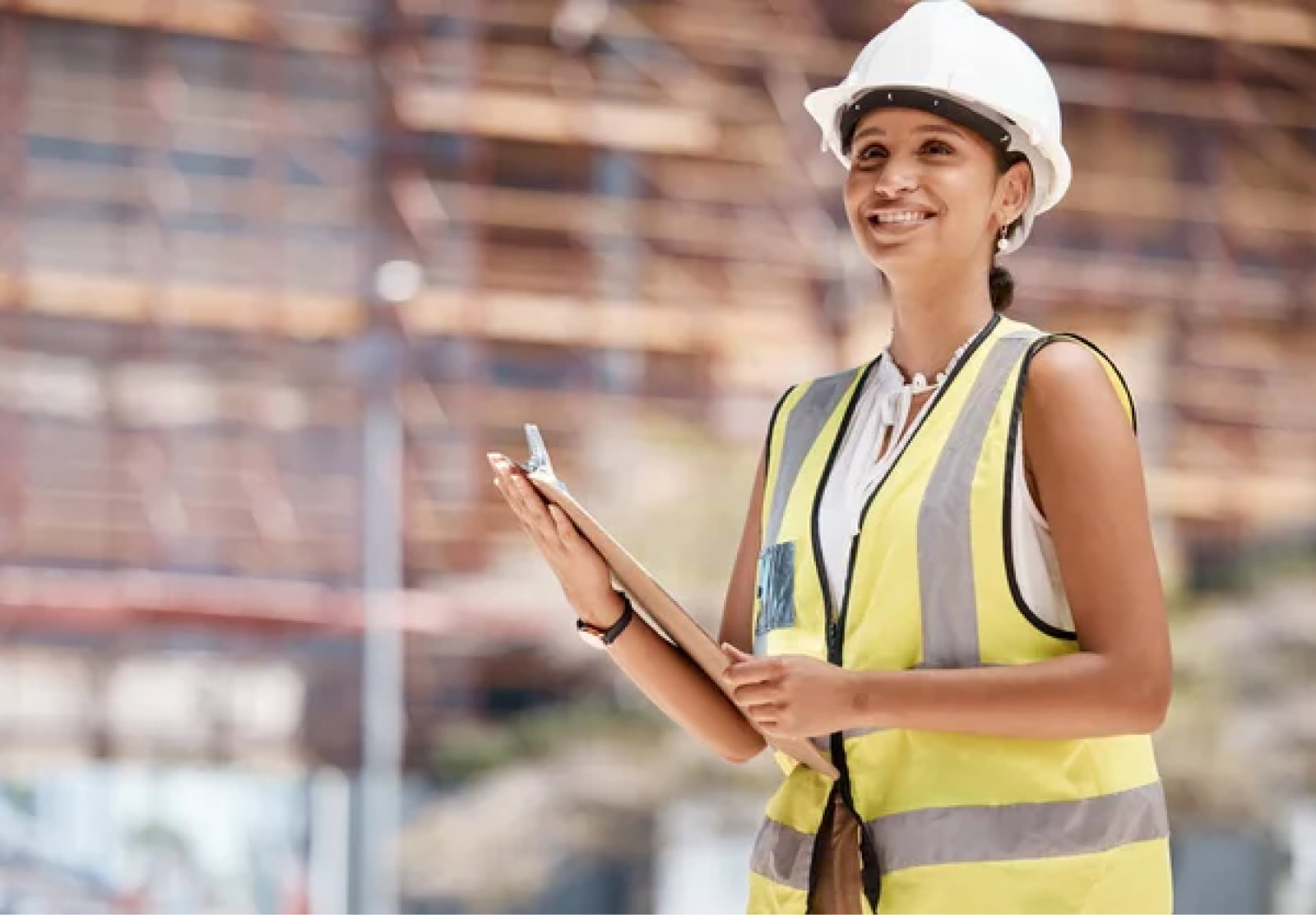 Smiling female construction worker in construction gear on a work site